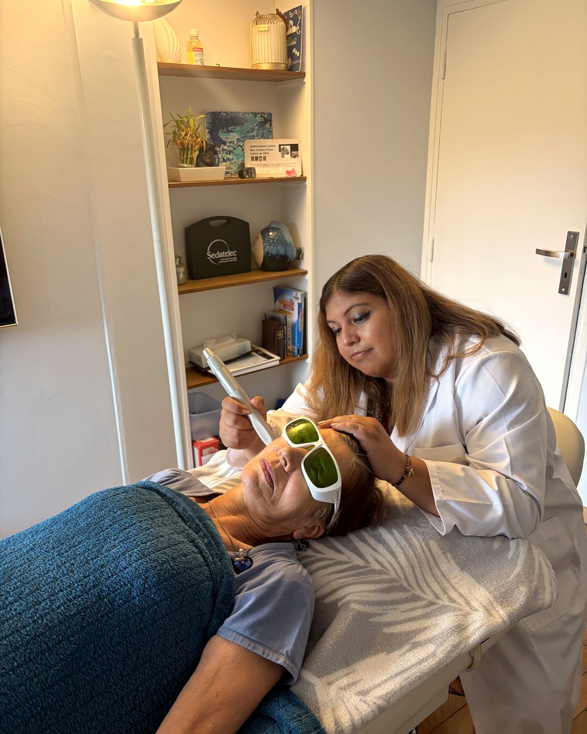 Anne-Sophie en séance de bio-stimulation laser dans son cabinet d'Amfreville-la-Mi-Voie : patiente allongée sur la table de soin, lunettes de protection en place