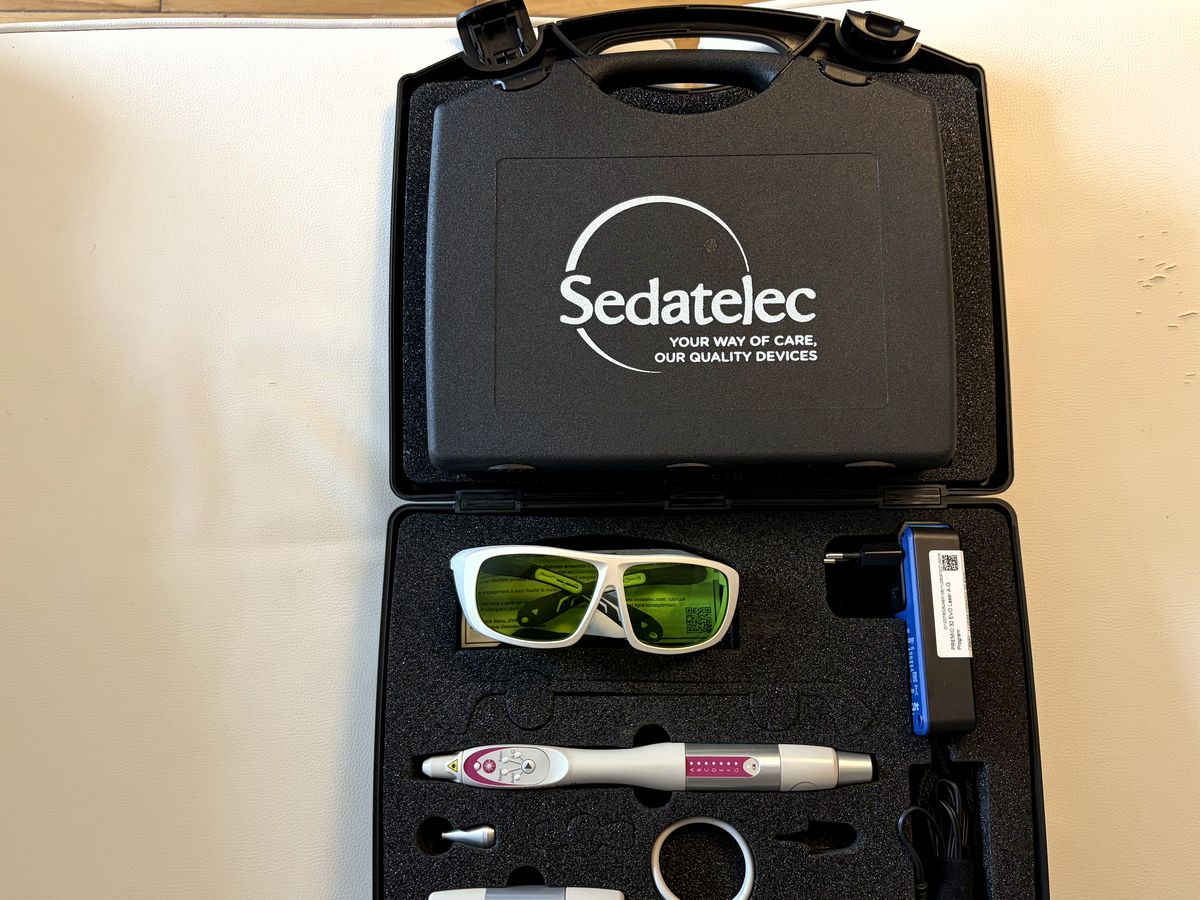 Le matériel du cabinet dans sa malette : stylo laser de photobiomodulation, lunettes de protection et accessoires
